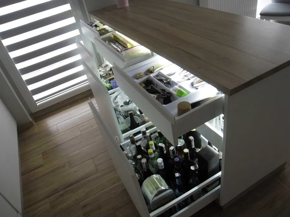 Otwarte szuflady z organizerem na butelki i systemy przechowywania